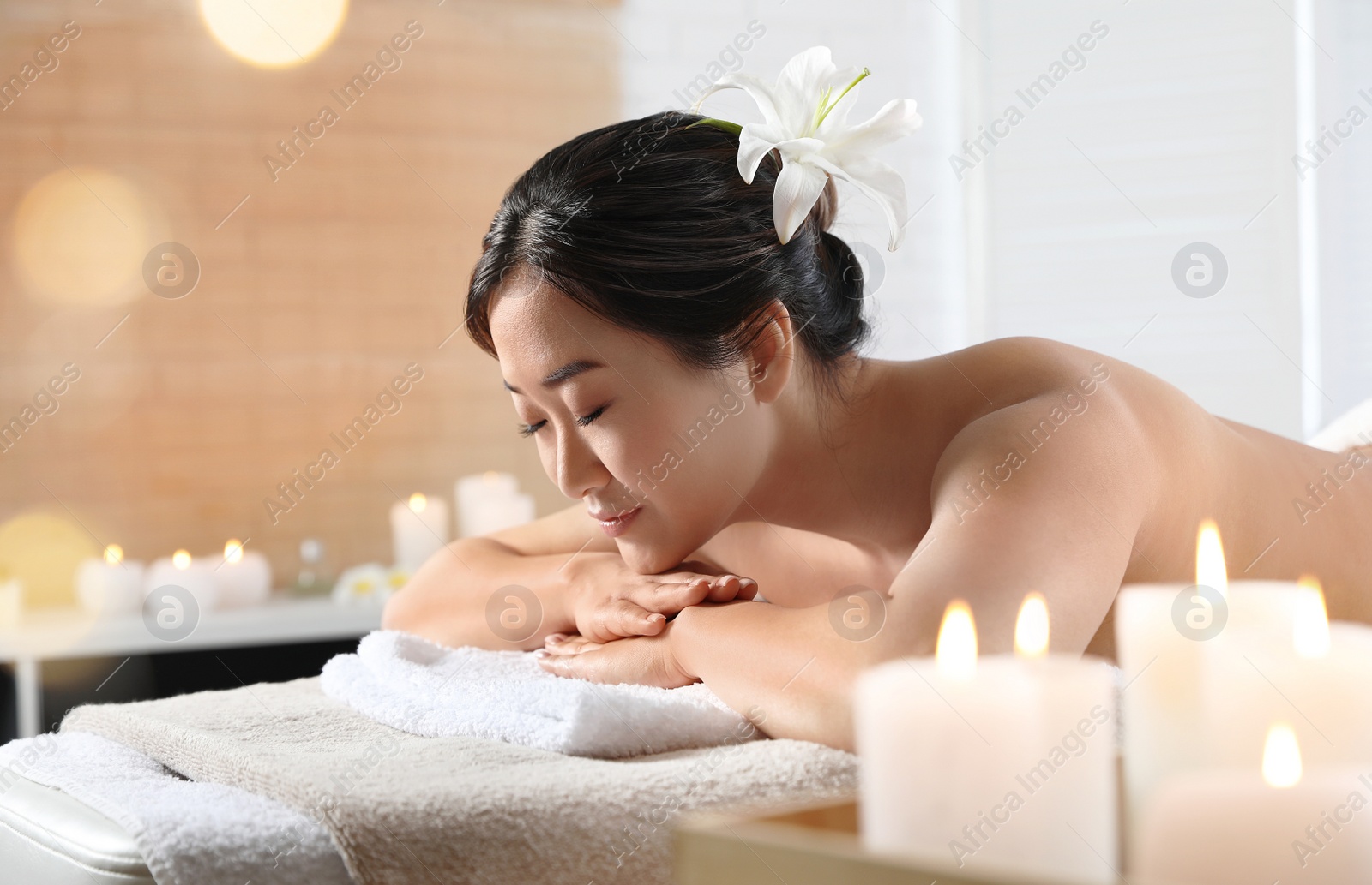 Photo of Beautiful Asian woman lying on massage table in spa salon