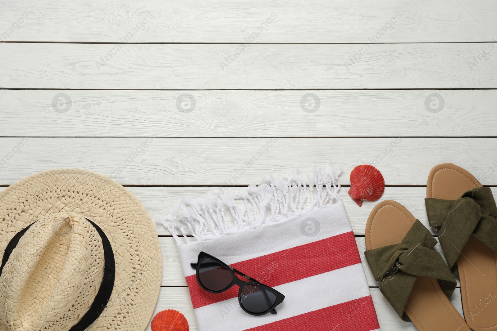 Photo of Beach towel, slippers, sunglasses and hat on white wooden background, flat lay. Space for text