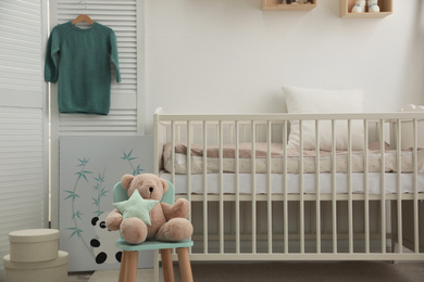 Stylish baby room interior with crib and toys