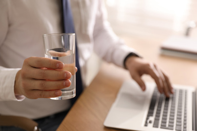 Photo of Office employee with glass of water at workplace, closeup