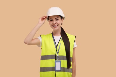 Photo of Engineer with hard hat and badge on beige background