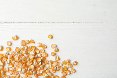 Photo of Raw dry corn seeds and space for text on white wooden background, flat lay. Vegetable planting