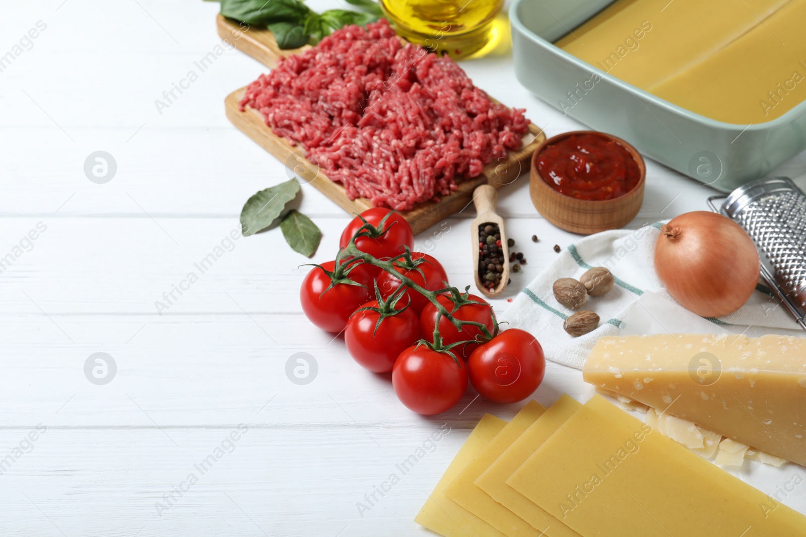 Photo of Fresh ingredients for lasagna on white wooden table