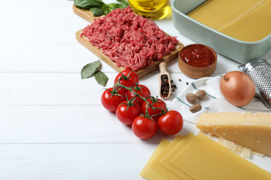 Fresh ingredients for lasagna on white wooden table