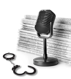 Image of Freedom of speech. Newspapers, microphone and handcuffs on white background