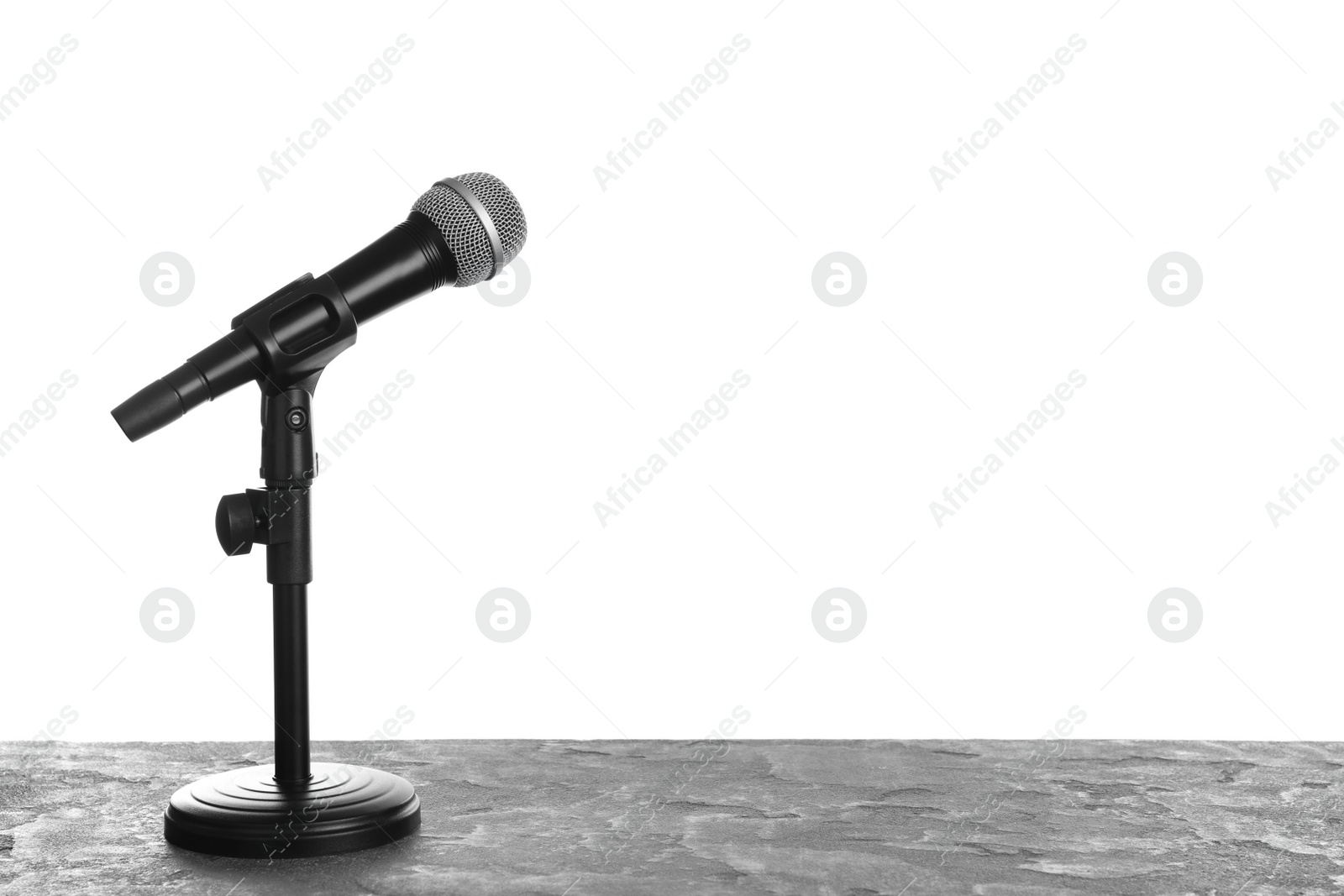 Photo of Modern microphone on table against white background. Space for text