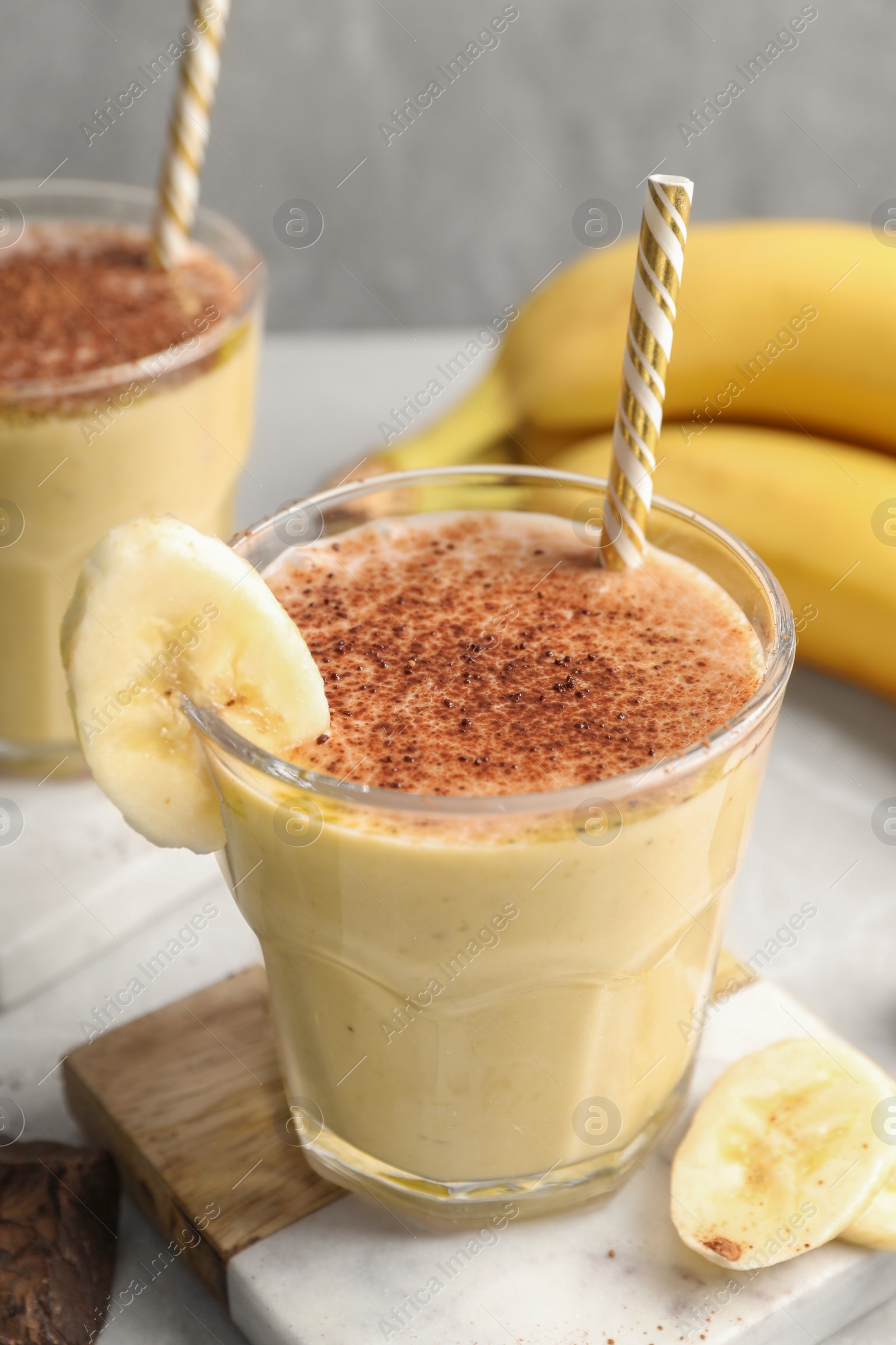 Photo of Tasty banana smoothie, fresh fruits and chocolate on white marble table