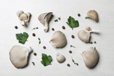 Photo of Flat lay composition with delicious organic oyster mushrooms and leaves on light background