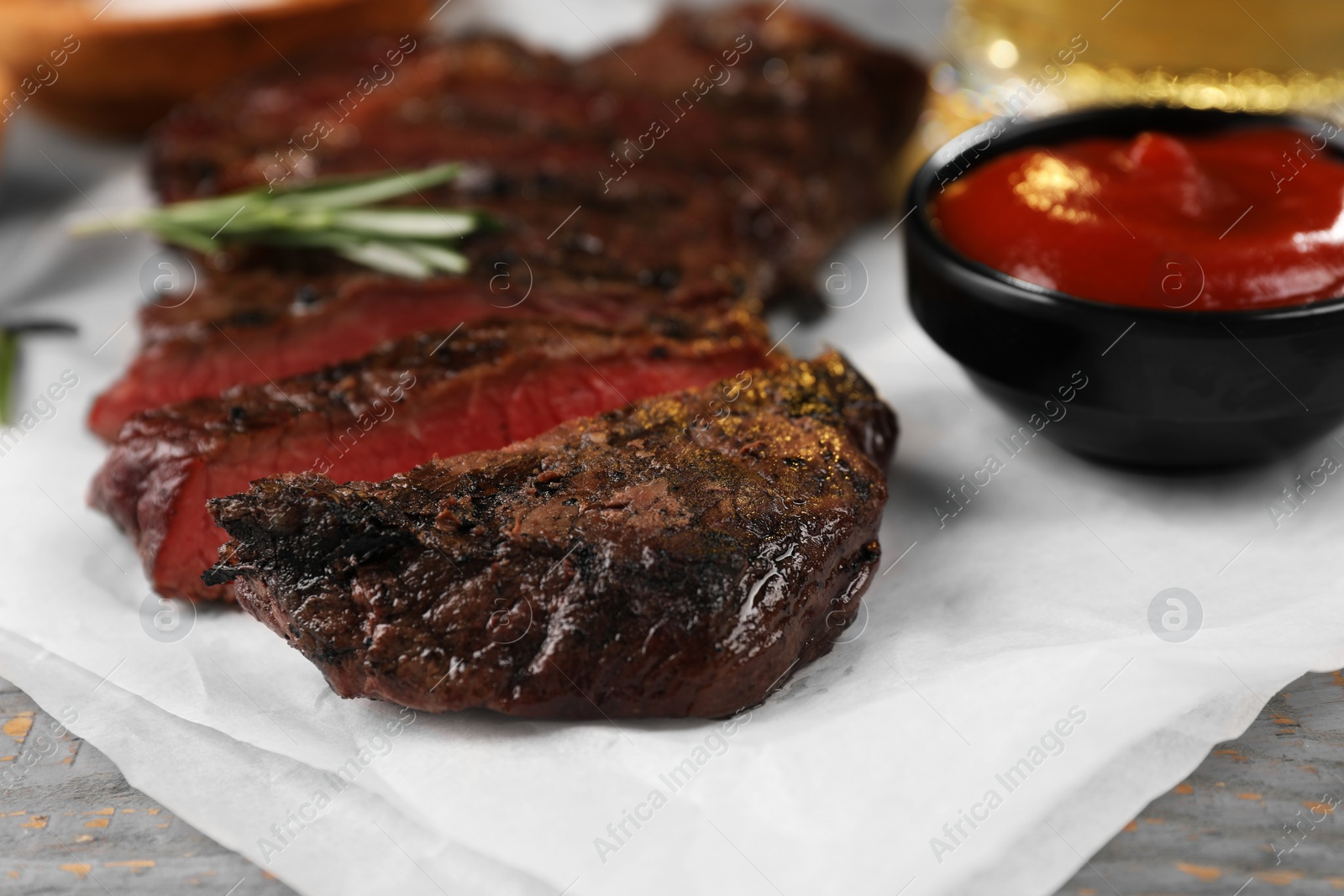 Photo of Delicious fried steak served on grey wooden table, closeup