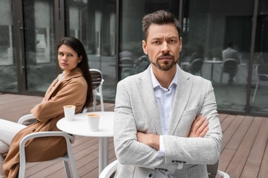 Upset arguing couple in outdoor cafe. Relationship problems