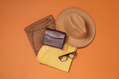 Flat lay composition with stylish hat on orange background
