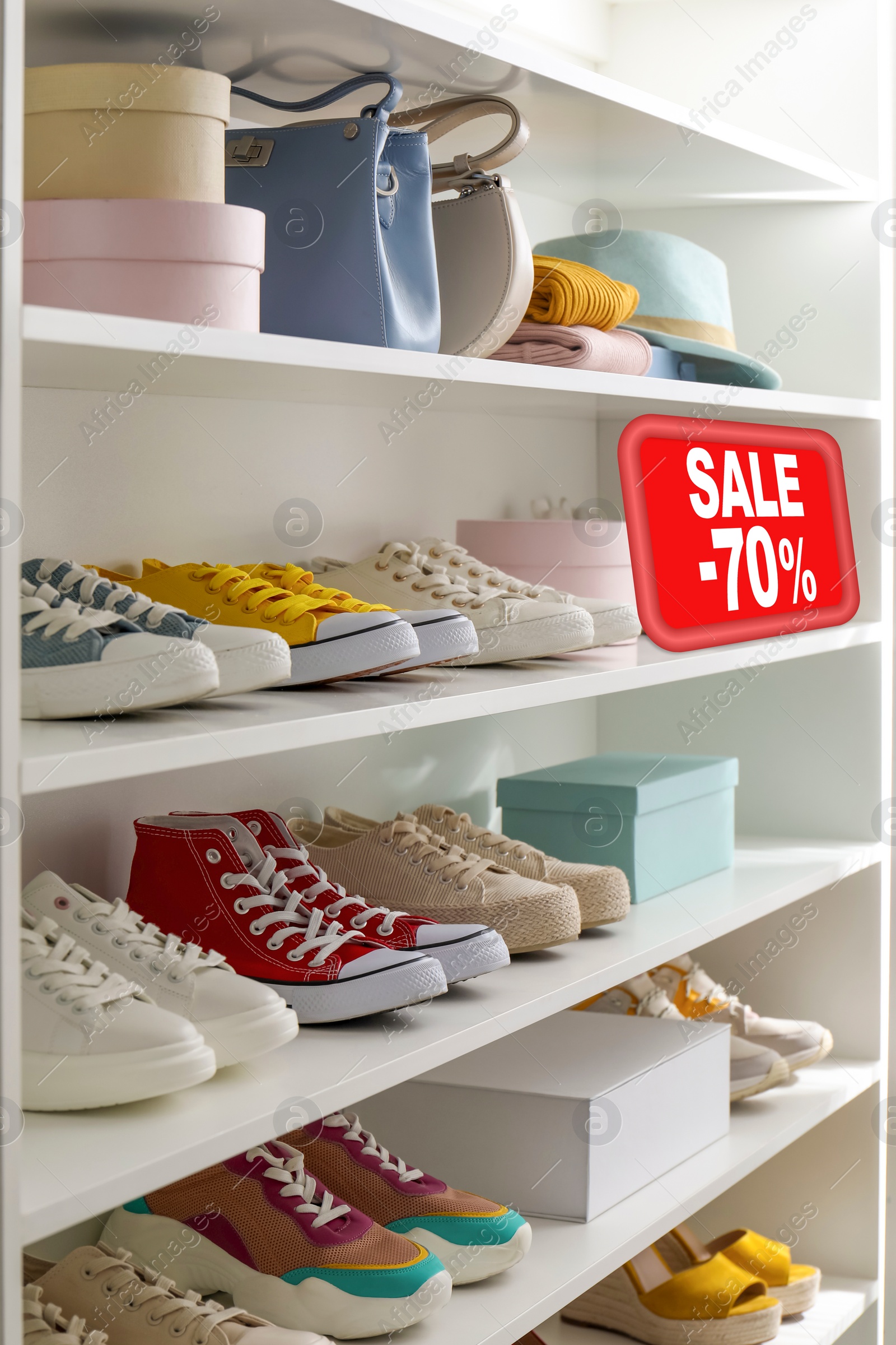 Image of Sale sign and shelving unit with collection of colorful shoes and accessories in modern boutique