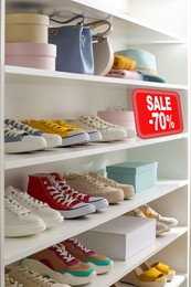 Image of Sale sign and shelving unit with collection of colorful shoes and accessories in modern boutique