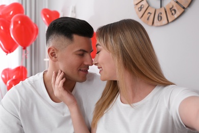 Photo of Lovely couple taking selfie at home. Valentine's day celebration