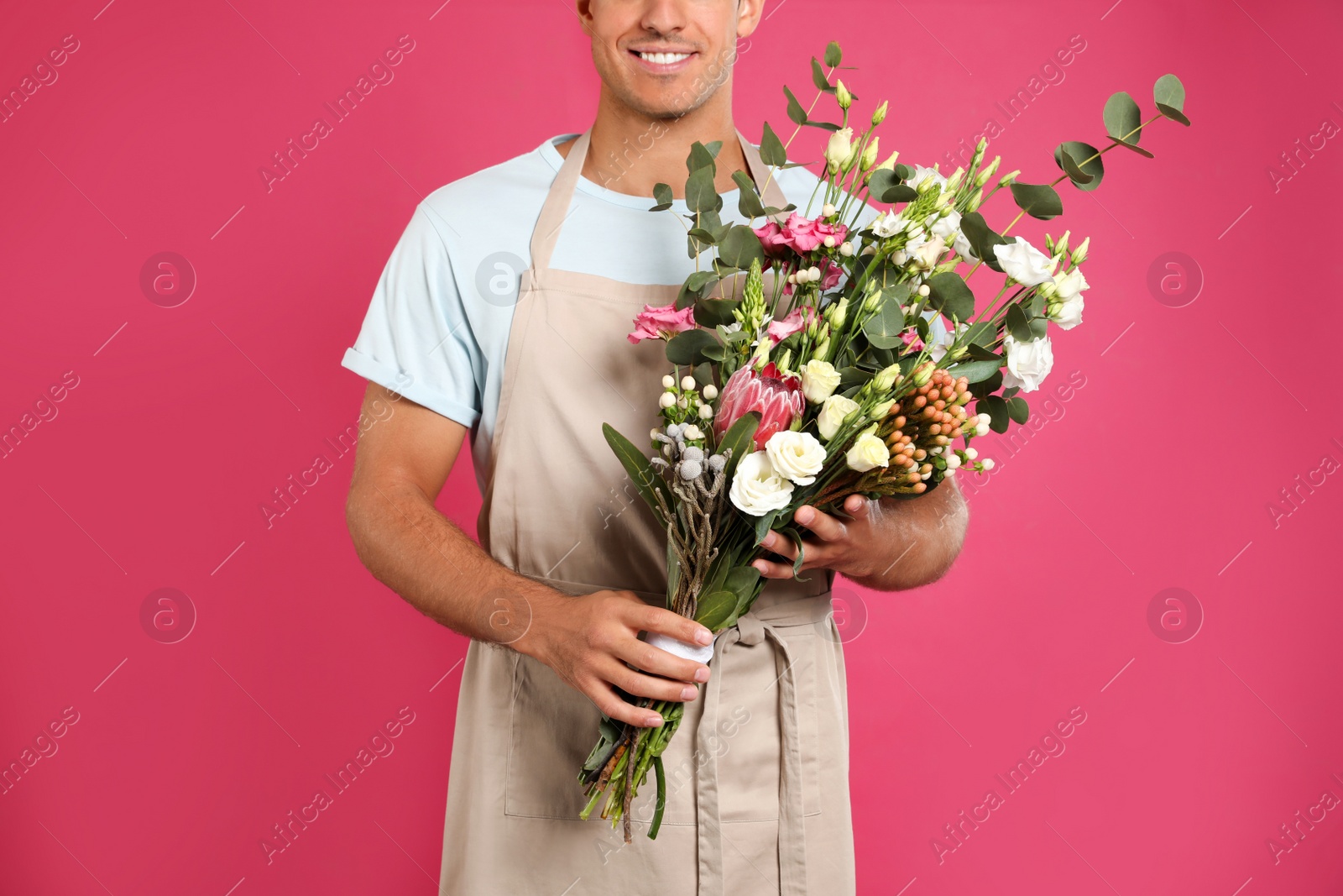 Photo of Florist with beautiful bouquet on pink background, closeup