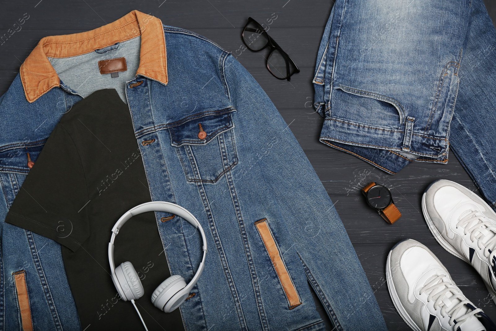 Photo of Set of stylish clothes and accessories on black wooden table, flat lay