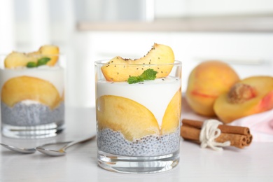 Tasty peach dessert with yogurt and chia seeds on white wooden table