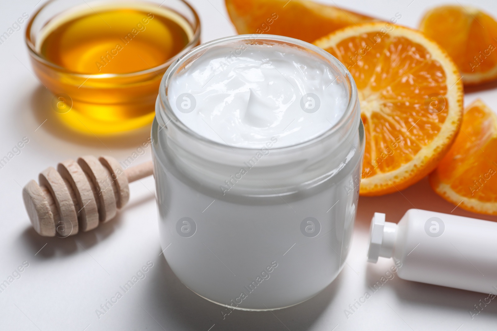 Photo of Different hand care cosmetic products, orange and honey on white background, closeup