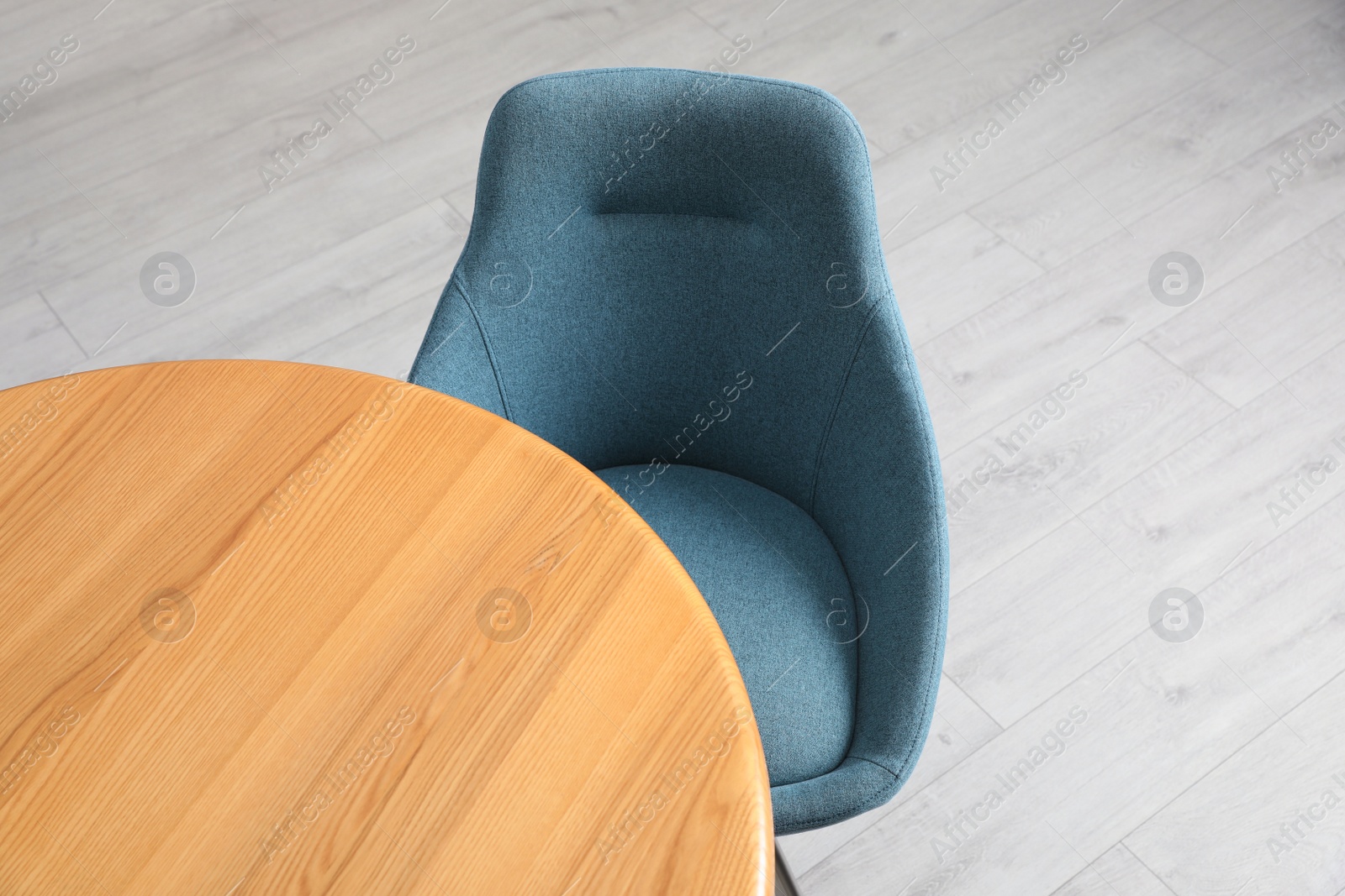 Photo of Stylish comfortable chair near wooden table in room, above view