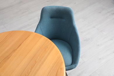 Photo of Stylish comfortable chair near wooden table in room, above view