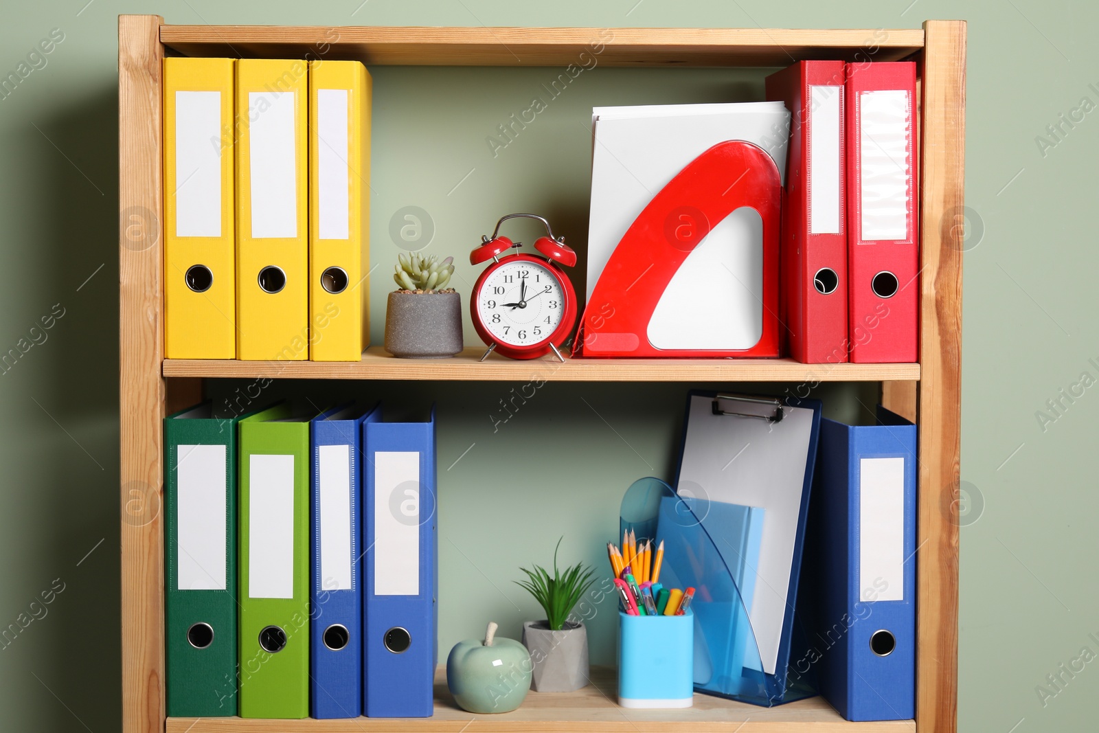 Photo of Colorful binder office folders and stationery on shelving unit indoors