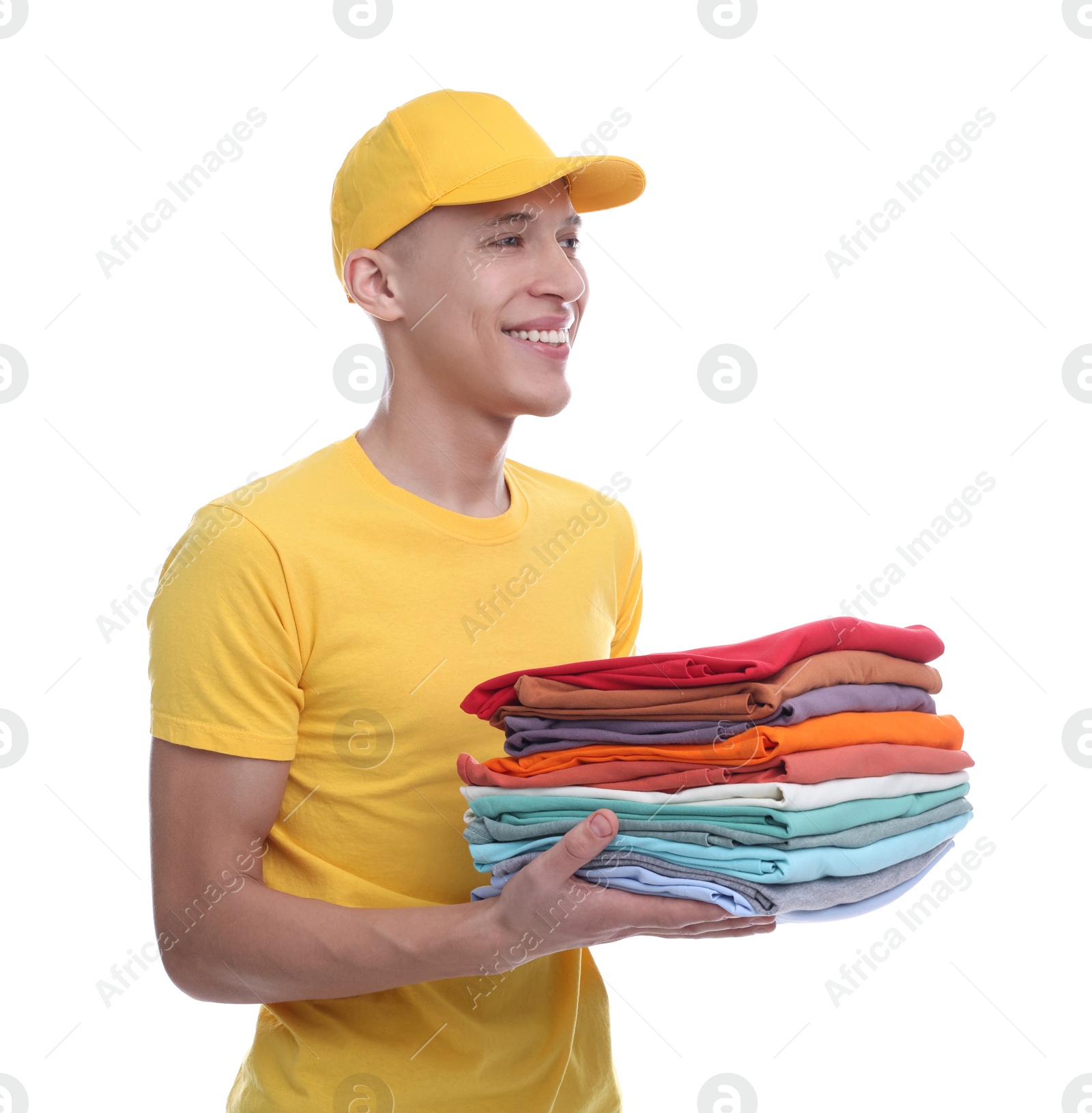 Photo of Dry-cleaning delivery. Happy courier holding folded clothes on white background