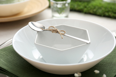 White dishes with spoon on table, closeup. Festive setting