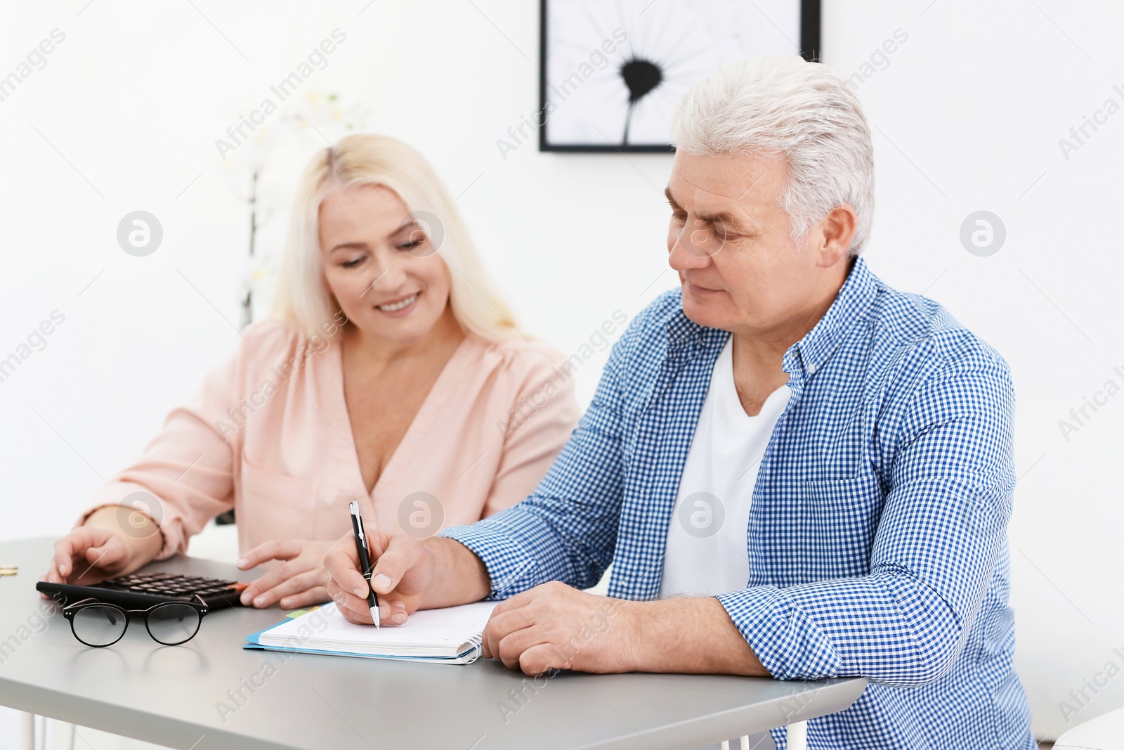 Photo of Mature couple thinking over pension payment at home