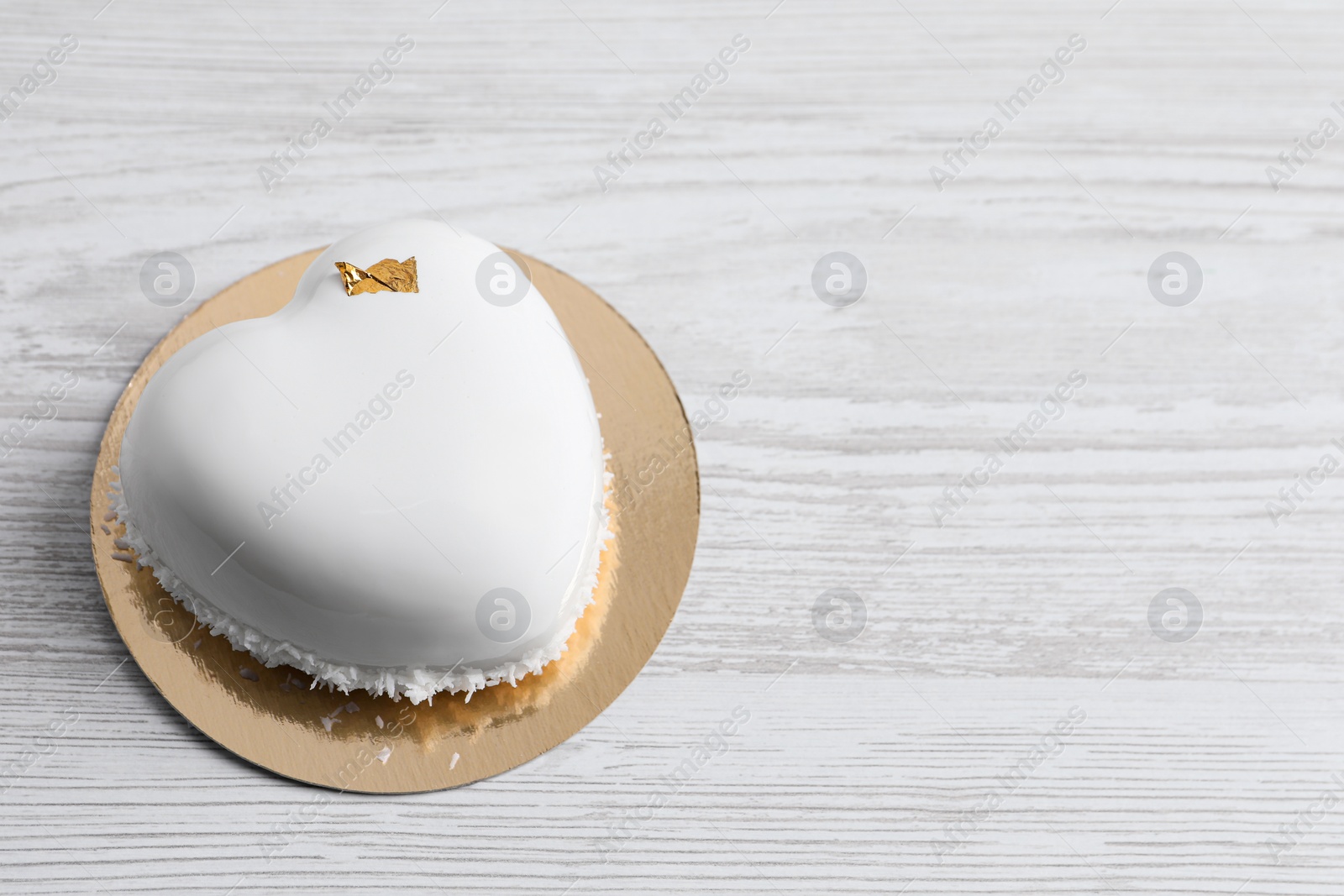 Photo of St. Valentine's Day. Delicious heart shaped cake on white wooden table. Space for text