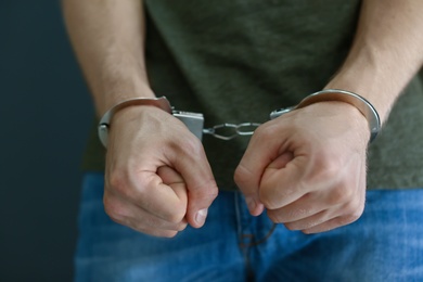 Photo of Man detained in handcuffs, closeup. Criminal law