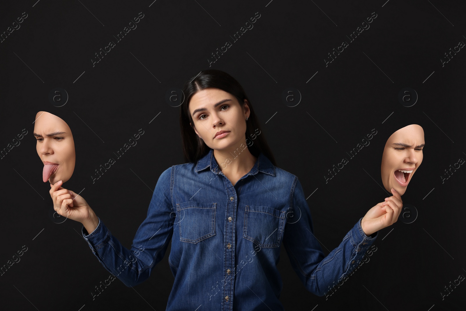 Image of Woman holding masks with her face showing different emotions on black background. Balanced personality