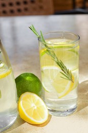 Photo of Tasty refreshing lemonade and ingredients on light table. Summer drink