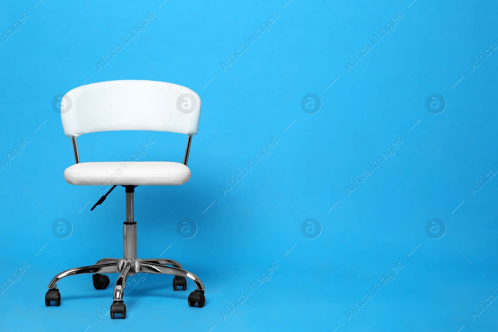 Photo of Comfortable office chair on light blue background, space for text