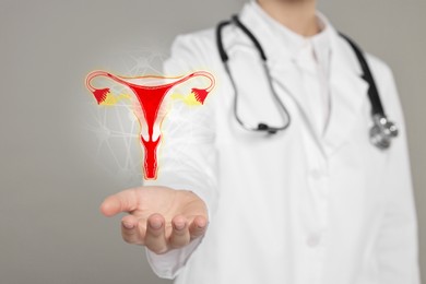 Image of Doctor and illustration of female reproductive system on grey background, closeup