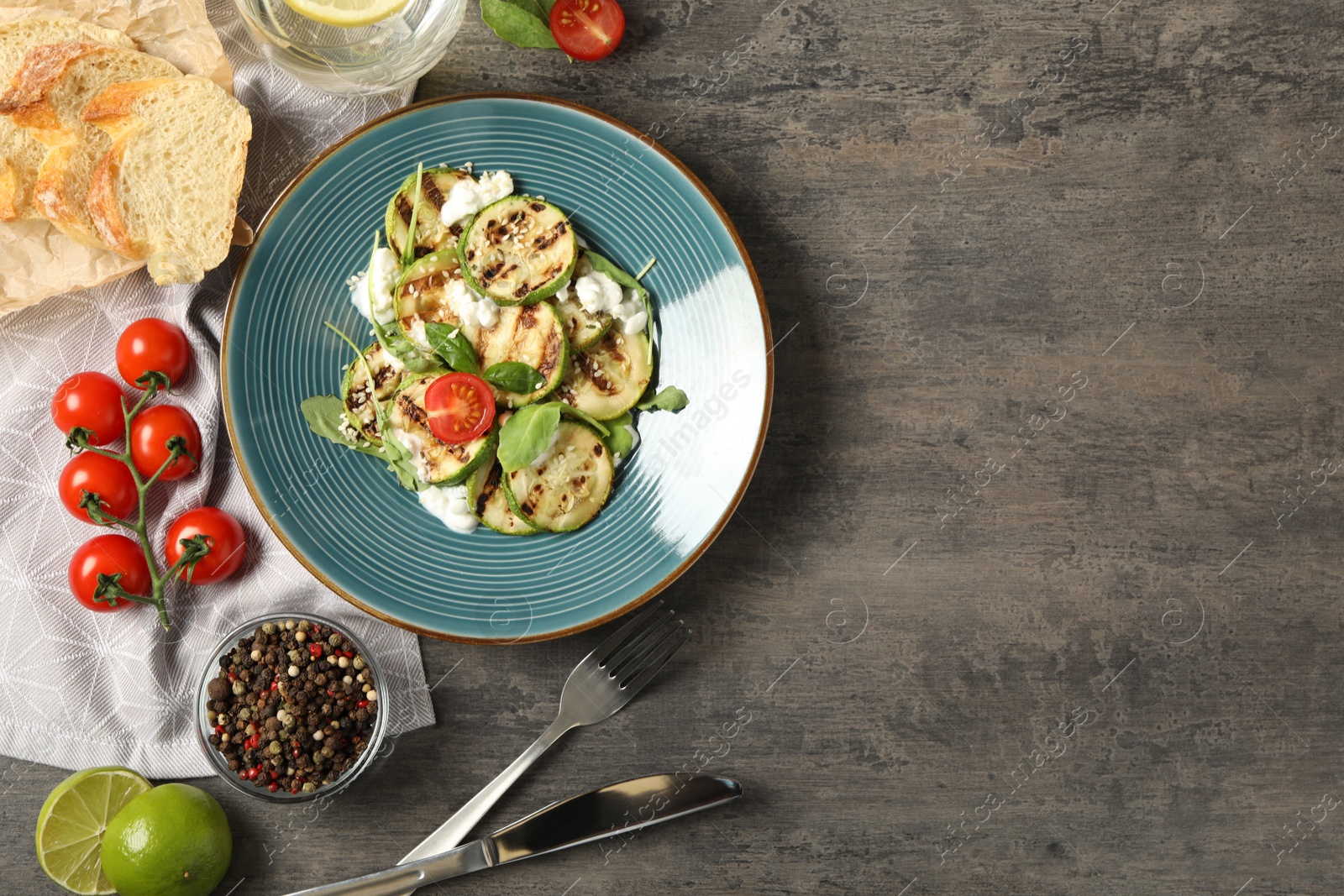 Photo of Flat lay composition with delicious grilled zucchini slices on grey table, space for text