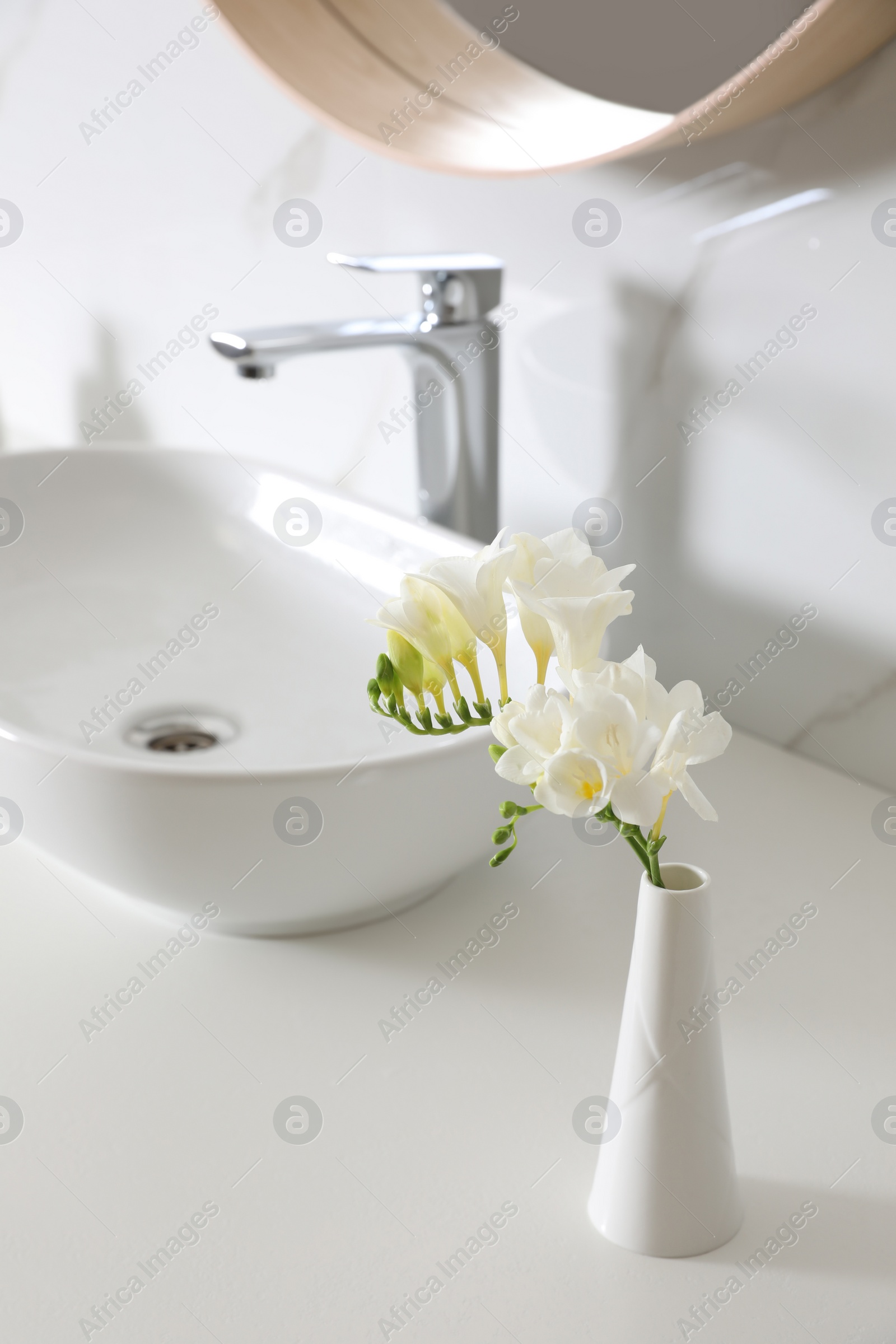 Photo of Beautiful bouquet with white freesia flowers in bathroom