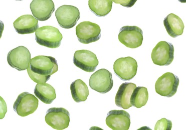 Slices of fresh green cucumbers falling on white background