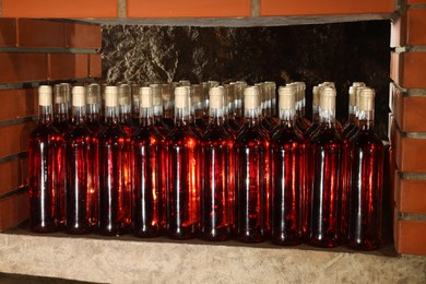 Photo of Many bottles of wine stored on shelf in cellar