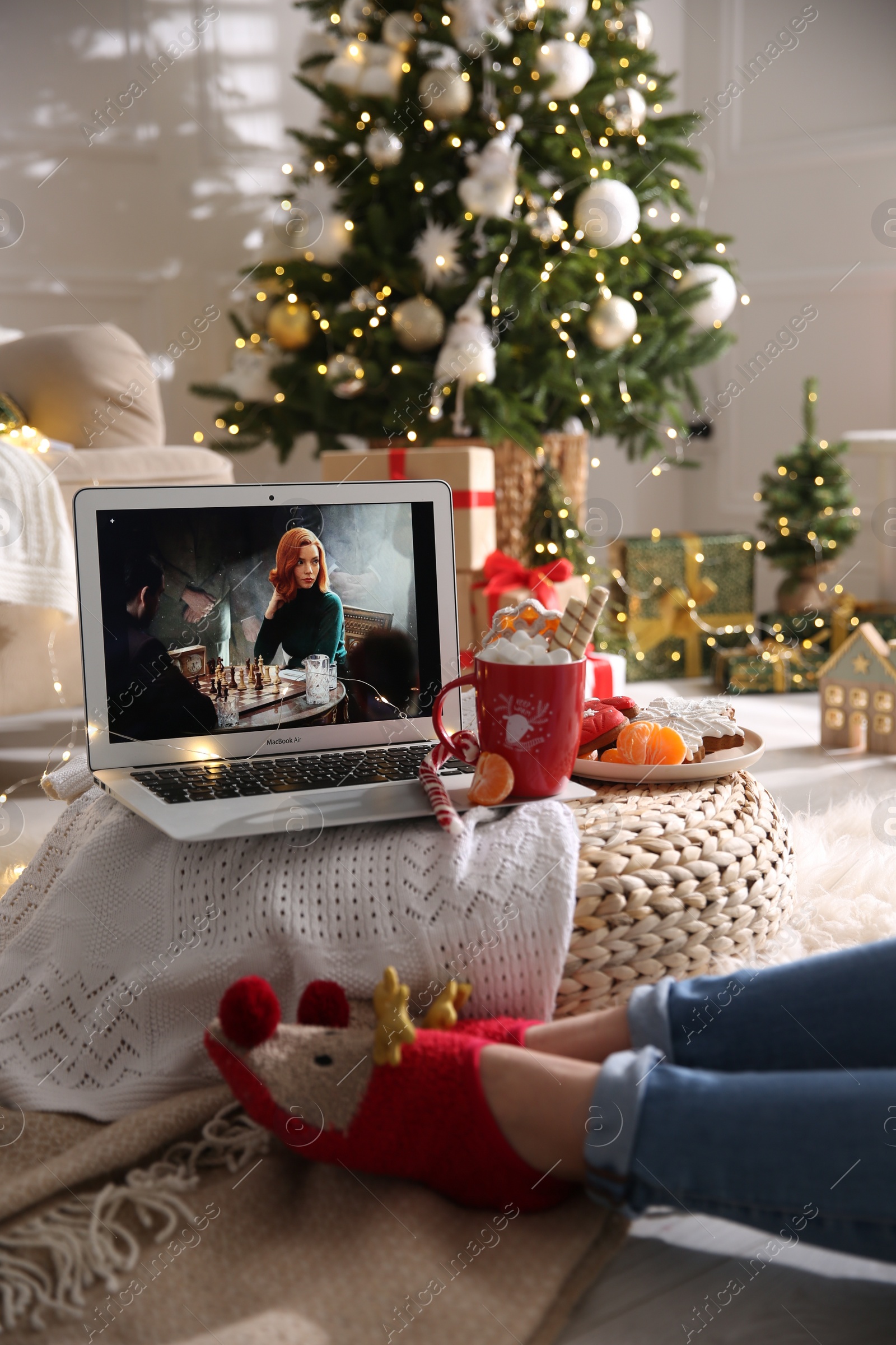 Photo of MYKOLAIV, UKRAINE - DECEMBER 25, 2020: Woman watching The Queen's Gambit series on laptop at home, closeup. Cozy winter holidays atmosphere