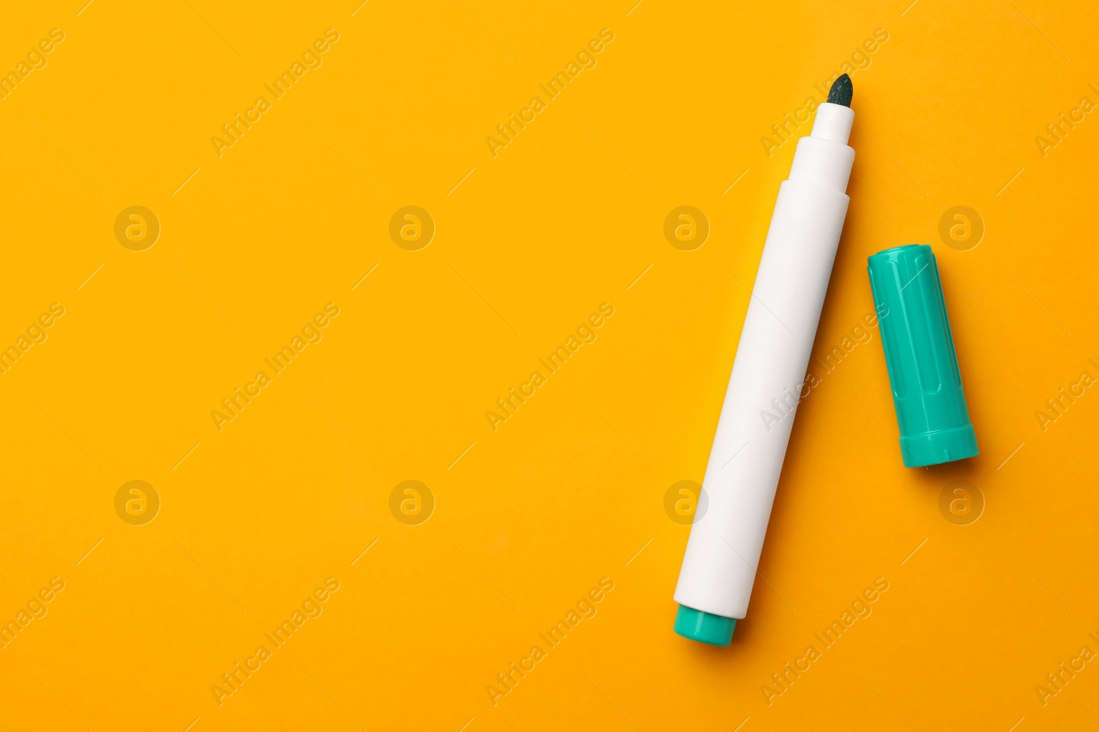 Photo of Bright green marker on orange background, flat lay. Space for text