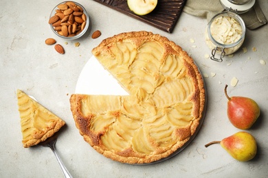Photo of Cut delicious sweet pear tart on grey table, flat lay