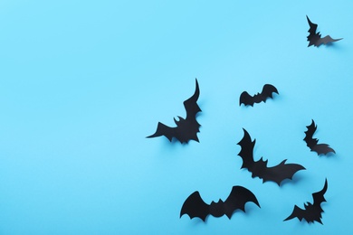 Photo of Paper bats on light blue background, flat lay with space for text. Halloween decor