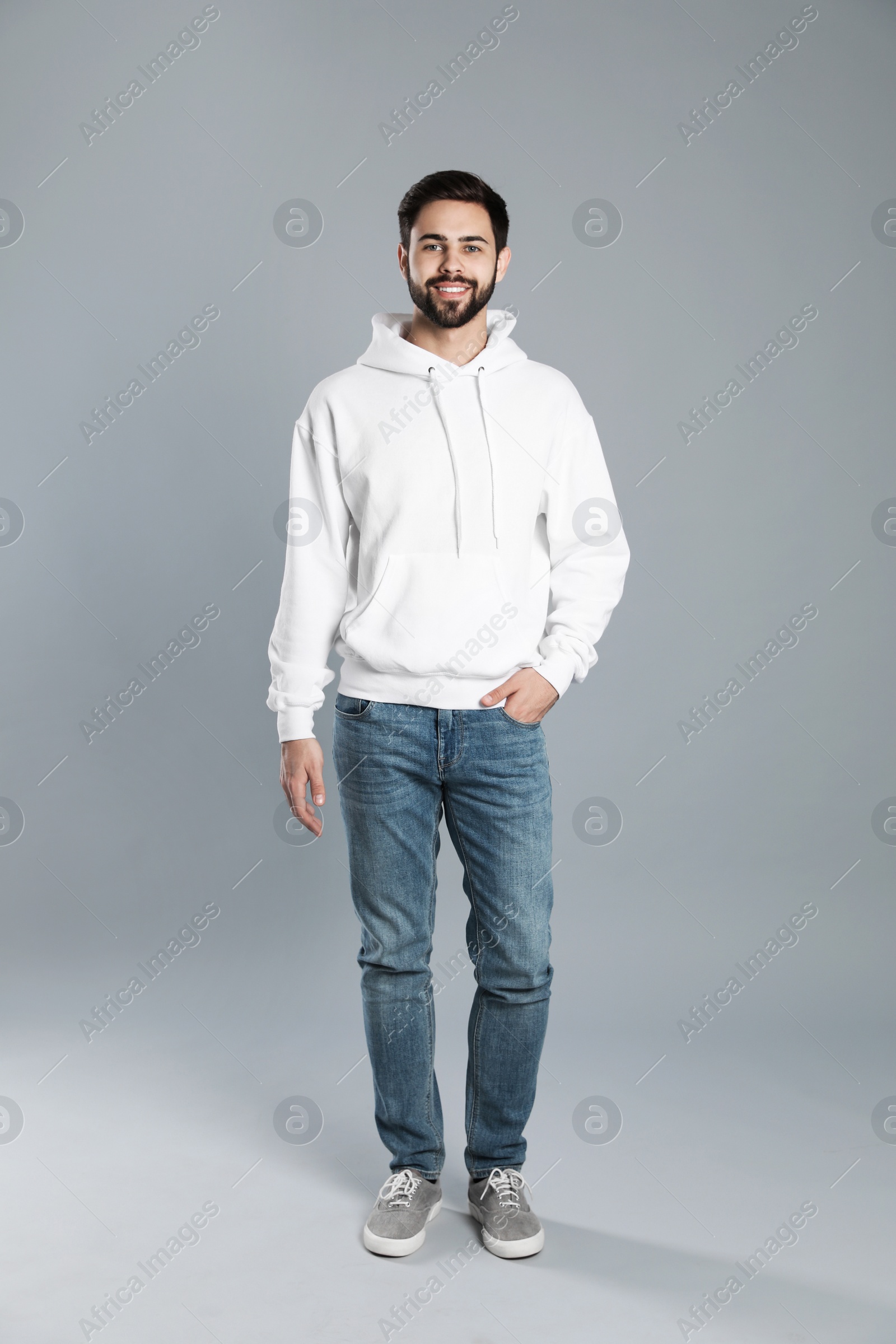 Photo of Full length portrait of young man in sweater on grey background. Mock up for design