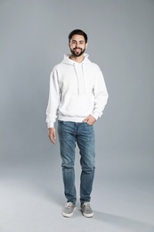 Full length portrait of young man in sweater on grey background. Mock up for design