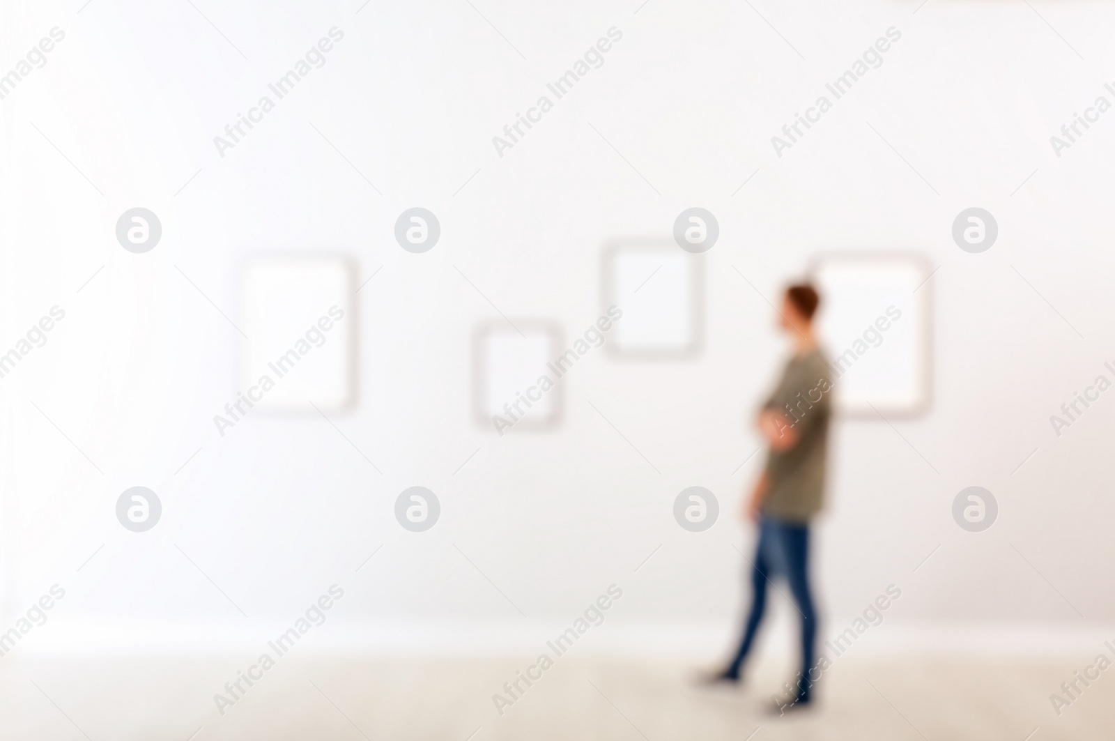 Photo of Young man in hall of modern art gallery, blurred view