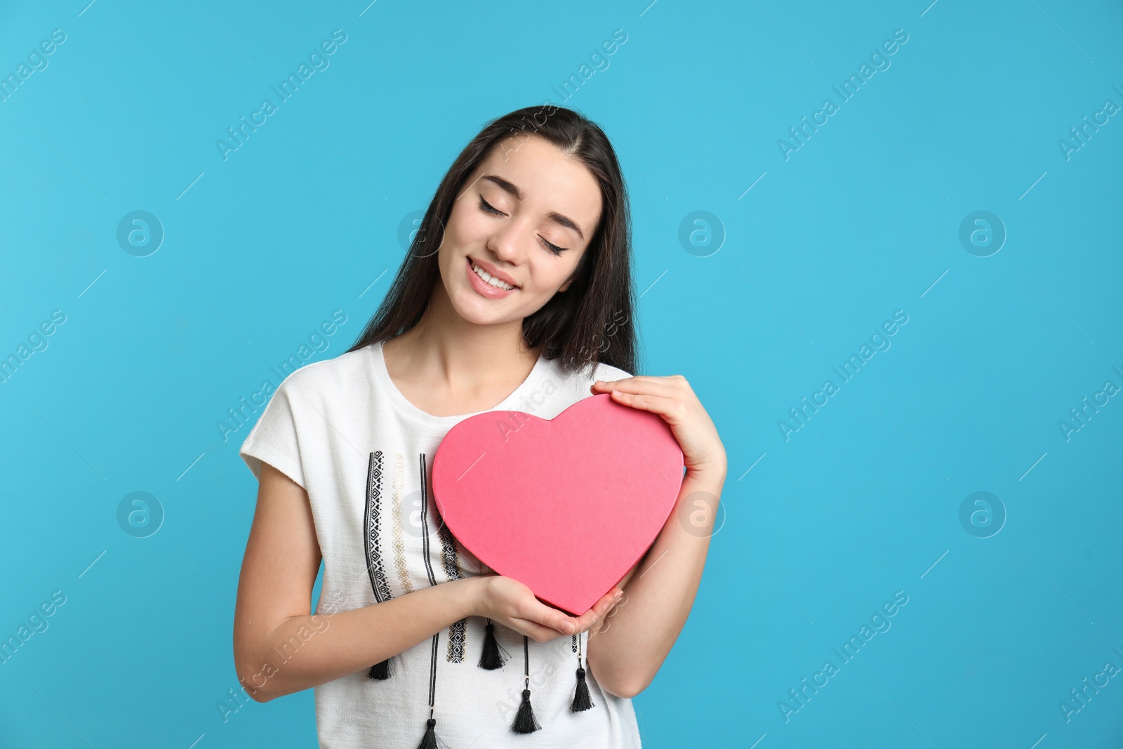 Photo of Portrait of beautiful young woman with decorative heart on color background