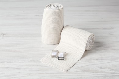 Photo of Medical bandage rolls on white wooden table