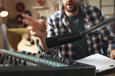 Photo of Man working as radio host in modern studio, closeup