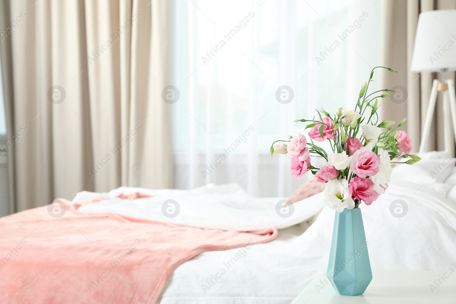 Photo of Vase with beautiful flowers on table in bedroom, space for text