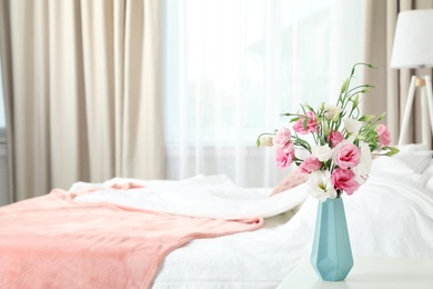 Photo of Vase with beautiful flowers on table in bedroom, space for text